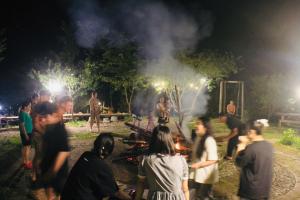 a group of people standing around a fire at night at Tao Tay House - Ta Van in Sapa