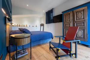 a bedroom with a bed and a table and a desk at Maison d'Hôte - La Motte Bleue in Rilhac-Lastours
