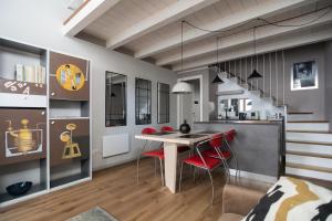 a kitchen and dining room with a table and red chairs at Casa degli Specchi- Duplex in city center in Arona +17 photos