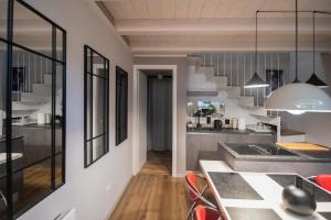 une cuisine avec une table et des chaises dans une pièce dans l'établissement Casa degli Specchi- Duplex in city center, à Arona 17 autres photos