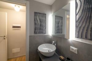 a bathroom with a sink and a mirror at Casa degli Specchi- Duplex in city center in Arona