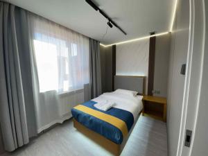 a small bedroom with a bed and a window at Yol Hotel in Dalandzadgad