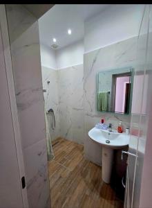 a white bathroom with a sink and a mirror at Shtepi,Apartament me qera , Pogradec in Pogradec