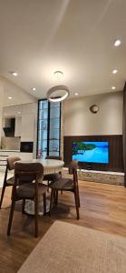 ein Esszimmer mit Tisch und Stühlen und einem Fernseher in der Unterkunft Sea Breeze Apart By La Casa in Nardaran