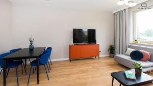 a living room with a table and a couch and a television at Rezydencja Wintera i Lastadia by Apartmore in Gdańsk +11 photos