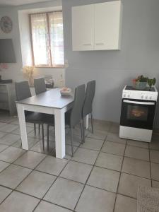 a white dining room table and chairs in a kitchen at La Solangette, petite maison confortable et calme in Bleigny-le-Carreau