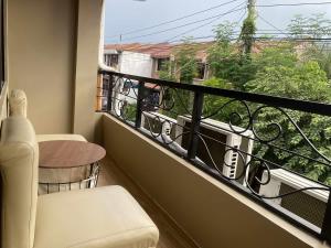 a balcony with a table and a chair and a window at Bakers Home stay in Tacondo