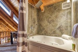 ein Badezimmer mit Badewanne und Dusche in der Unterkunft Laceys Place By Beyond Expectations W Hot Tub in Sevierville + 40 Fotos