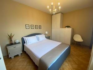 a bedroom with a large bed and a chandelier at Casa Marcobando - Lucca in Lucca
