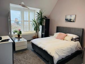 a bedroom with a bed and a desk and a window at Penthouse Suite, Sea View, Close to Shops, Beach and Train in St. Leonards