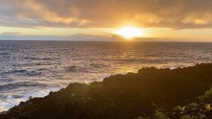 a sunset over the ocean with the sun setting at Oceanfront studio see whales and dolphins in Pahoa