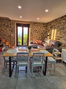 a room with a table and chairs and a couch at A Luz do Faro in Muxia