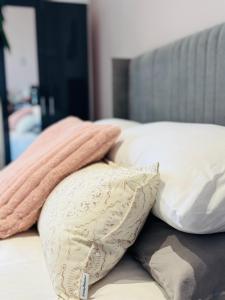 un montón de almohadas encima de una cama en Penthouse Suite, Sea View, Close to Shops, Beach and Train, en St. Leonards