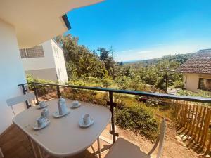 a white table and chairs on a balcony with a view at Helles Apartment Bergblick Nähe Messe Frankfurt in Bad Soden am Taunus
