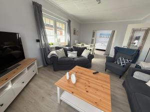 Una sala de estar con un sofá y un televisor. en Haus Inseltraum, en Fehmarn