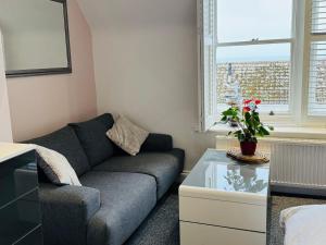 a living room with a couch and a table at Penthouse Suite, Sea View, Close to Shops, Beach and Train in St. Leonards
