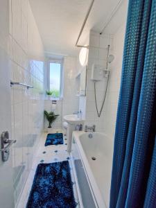 a bathroom with a tub and a sink and a shower at NEW, Refurbished Modern & Spacious 1 Bed Flat Westfield Shepherd's Bush Free Wi-Fi Super King Bed in London