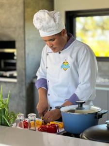 a chef standing in a kitchen preparing food at Nossa Casa | Frente Mar, 5 Suítes Exclusivas in Praia do Forte +35 photos