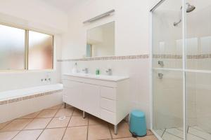 a white bathroom with a sink and a shower at Amelia Rose Estate in Lovedale +20 photos