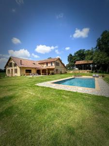 a house with a swimming pool in the yard at Maison Puchouaou Gîte 8 ou 12 personnes avec piscine privée in Montesquiou