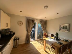 a kitchen and dining room with a table and a clock at 5A Retallack Resort & Spa in Saint Columb Major