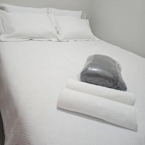 ein Bett mit weißen Laken und Handtüchern darauf in der Unterkunft Saint Charles Hostel in São Carlos + 19 Fotos