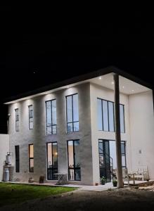 - un grand bâtiment blanc avec de grandes fenêtres la nuit dans l'établissement Loft Céntrico Cedral, à Cedral