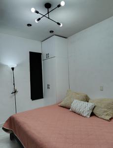 une chambre avec un lit et un ventilateur de plafond dans l'établissement Loft Céntrico Cedral, à Cedral