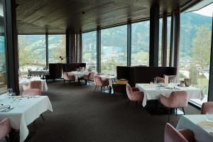 a restaurant with white tables and chairs and windows at HELD - Hotel & Spa , 4 Sterne Superior, Zillertal in Fügen
