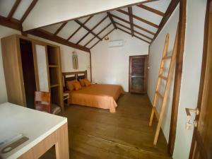 a bedroom with a bed and a wooden floor at Gaia cottages in Gili Trawangan