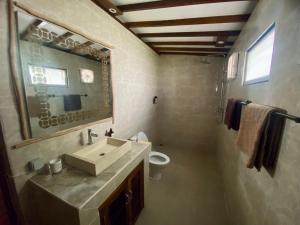 a bathroom with a sink and a toilet and a mirror at Gaia cottages in Gili Trawangan