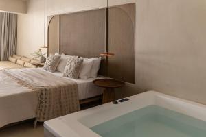 卡尔扎迈纳Elea Luxury suites的带床和浴缸的酒店房间