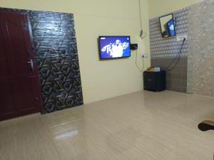 a room with a door and a tv on a wall at Johan home stay AC in Thiruchendur