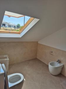 a bathroom with a toilet and a sink at A Luz do Faro in Muxia +39 photos