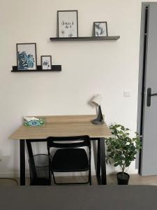 a desk with a lamp and a chair in a room at Chez Jules, appartement tout confort de 40 m2 in Denain