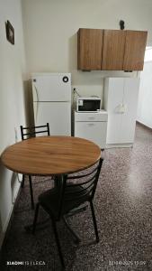 a small kitchen with a table and a refrigerator at Dpto de Licia in Cipolletti