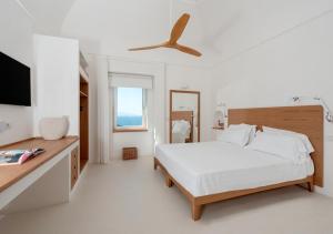 卡普里Maison Mia Capri的一间带床和电视的白色卧室