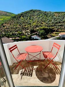 a red table and two chairs on a balcony at Casa Tawny in Pinhão +34 photos
