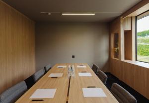 ein Konferenzraum mit einem langen Holztisch und Stühlen in der Unterkunft 瀾山ホテル LanshanHotel 澜山酒店 in Horonai