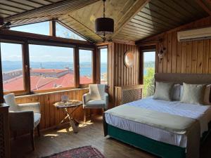 Un dormitorio con una cama en una habitación con ventanas. en Denizci Hotel, en Sinope