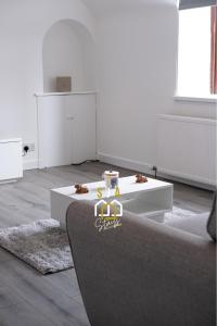 a white room with a table in the middle at Hay Residence - SJA Stays – Modern 3 Bed Apartment in Peterhead