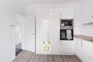 a kitchen with white cabinets and a microwave at Hay Residence - SJA Stays – Modern 3 Bed Apartment in Peterhead +17 photos