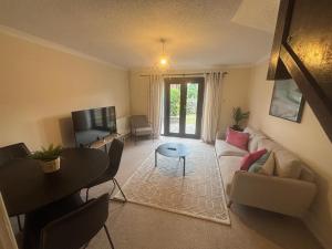 a living room with a couch and a table at Comfortable 2 Bedroom House in Bracknell in Bracknell +5 photos