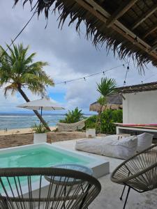 a patio with a table and chairs and the beach at Aloha Pacifico Beach House in San Isidro