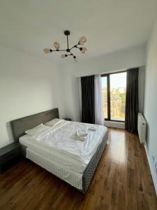 a bedroom with a bed and a large window at Ap nou cu 2 camere in centrul Bucureștiului in Bucharest
