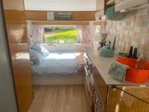 a small kitchen with a bed in a tiny house at Major Tom in Commana