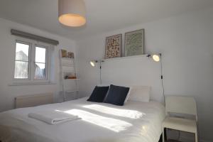 a bedroom with a white bed with blue pillows at Warfield Charming Three Bedroom House in Warfield