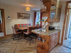 a kitchen with a table and a dining room at Goulane Farmhouse in Boolacullane