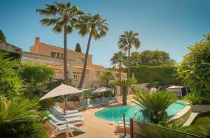 ośrodek z basenem, krzesłami i palmami w obiekcie FRGK Luxury Villa in Antibes Heated Pool Spa w mieście Antibes