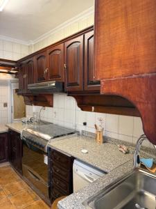 a kitchen with wooden cabinets and a sink at Comfyheliopolis in Cairo